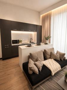 a living room with a couch and a kitchen at Rebecca's Noir Suite in Reggio Emilia +14 photos