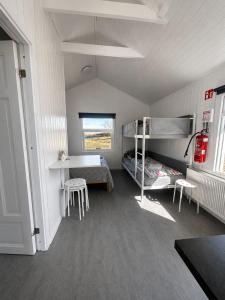 a room with a bunk bed and two stools at Arhus Cottage and Camping in Hella