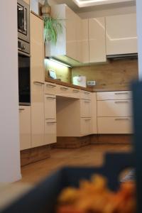a kitchen with white cabinets and a plant at Lenz Stay - Ganzes Ferienhaus mit privatem Garten in Kaisersberg