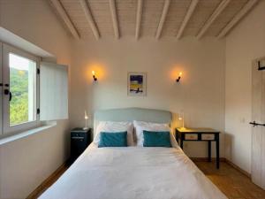 a bedroom with a large white bed with two blue pillows at Tina`s House - Bordeira in Aljezur