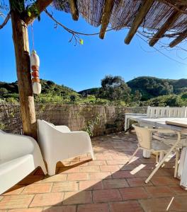 a patio with a table and chairs on a brick patio at Tina`s House - Bordeira in Aljezur