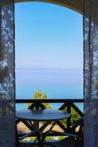 a table on a balcony with a view of the ocean at Anthema Apartments in Kalogria