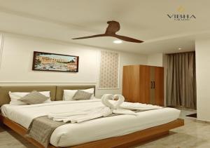 a bedroom with a large bed with a ceiling fan at Hotel Vibha Grand in Karīmnagar +10 photos