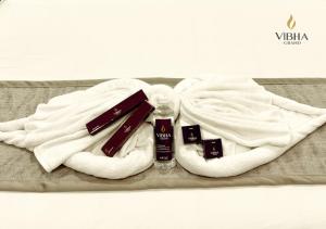 a pile of towels and cosmetics sitting on a bed at Hotel Vibha Grand in Karīmnagar