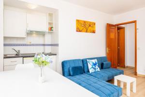 a living room with a blue couch and a table at Apartamento Felipe 1-4 in Cala d´Or
