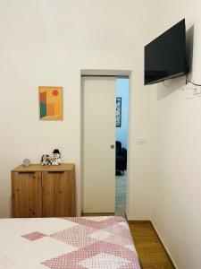 a bedroom with a bed and a television on a wall at Alpine Cozy Studio Limone Piemonte in Limone Piemonte