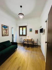 a living room with a green couch and a table at Alpine Cozy Studio Limone Piemonte in Limone Piemonte +13 photos