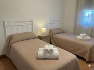 a room with two beds with towels on them at Villa rural en Marchena in Marchena