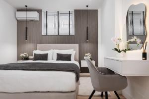 a bedroom with a bed and a desk and a chair at Aura Airport Suite in Spata