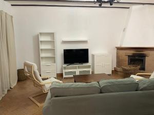 a living room with a couch and a tv at Villa rural en Marchena in Marchena