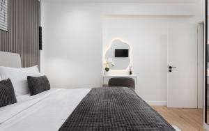 a white bedroom with a bed and a mirror at Aura Airport Suite in Spata +17 photos
