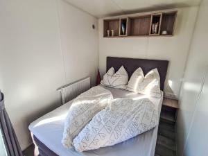 a small bedroom with a bed with white sheets and pillows at Holiday Home Tiny Haus Heidi by Interhome in Beilngries