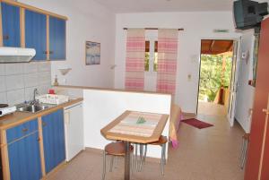 a kitchen with blue cabinets and a table in it at Galini Apartments in Palekastron