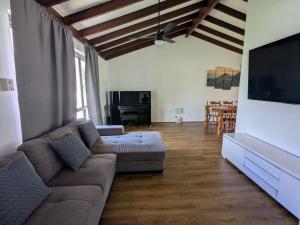 a living room with a couch and a flat screen tv at 3-Bed home with large backyard in Mandurah