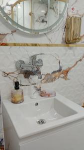 a bathroom with a white sink and a mirror at Steady - Guests Rooms in Varna City