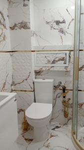 a bathroom with a white toilet and marble walls at Steady - Guests Rooms in Varna City