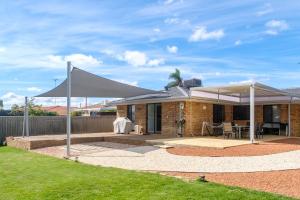 a house with a large white canopy in a yard at 3-Bed home with large backyard in Mandurah