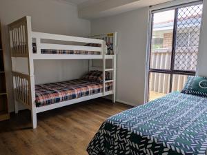 a bedroom with two bunk beds and a bed at 3-Bed home with large backyard in Mandurah