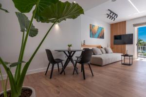 ein Wohnzimmer mit einem Tisch und einem Sofa in der Unterkunft WALK2BEACH Riviera Beachfront Luxury Studio Suite - Steps to Yabanaki Varkiza in Varkiza