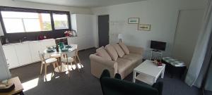ein Wohnzimmer mit Sofa und Tisch in der Unterkunft Appartement neuf avec balcon - Vue mer - Crozon in Crozon