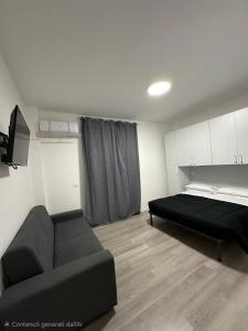 a bedroom with a bed and a couch in it at Prestige House 6 in Scalea