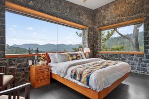 a bedroom with a bed and a large window at SaffronStays Blooming Stone in Kotagiri