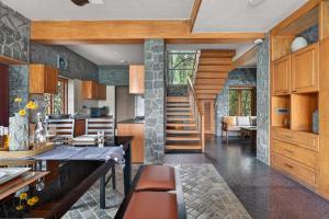 a kitchen with wooden cabinets and a staircase in a house at SaffronStays Blooming Stone in Kotagiri