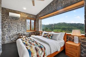 a bedroom with a bed and a large window at SaffronStays Blooming Stone in Kotagiri