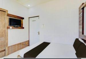 a bedroom with a bed and a door with a television at Hotel Haji Ali - Sahil inn in Ajmer +13 photos