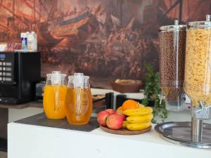 a counter with two glasses of orange juice and fruit at Lepanto Guesthouse in Misraħ Il-Barrieri +27 photos