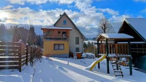 a house in the snow with a slide at Wellness apartmán TERASA in Bozkovska
