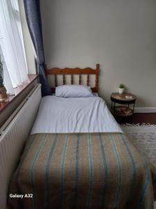 a small bed in a room with a window at Fishing in Foxford