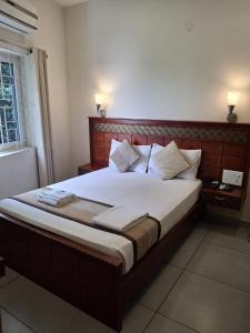 a bedroom with a large bed with a wooden headboard at ROYAL RESIDENCY Ac in Virudunagar