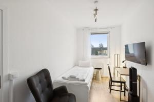 a white living room with a couch and a table at Am Ring Monteurzimmer Apartment Böhlen in Böhlen