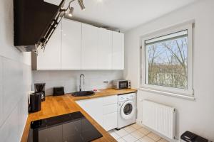 a kitchen with white cabinets and a washer and dryer at Am Ring Monteurzimmer Apartment Böhlen in Böhlen