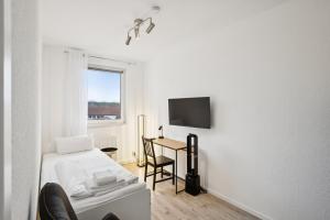 a room with a bed and a desk and a tv at Am Ring Monteurzimmer Apartment Böhlen in Böhlen