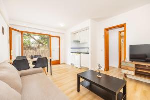 a living room with a couch and a tv and a table at Apartamento Felipe 1-3 in Cacla D'or
