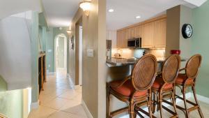 a kitchen with a bar with four chairs in it at 203 Mariners Club in Key Largo