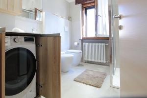 a bathroom with a washing machine and a toilet at House Angy in Ponte nellʼAlpi +29 photos