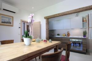 a kitchen with a wooden table and a dining room at House Angy in Ponte nellʼAlpi