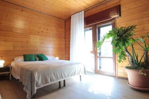 a bedroom with a bed in a wooden wall at House Angy in Ponte nellʼAlpi