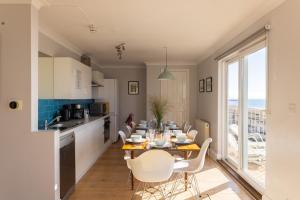 a kitchen and dining room with a table and chairs at Pier Court Apartments Brighton in Brighton & Hove
