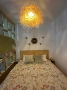 a bedroom with a bed and a large chandelier at Casa Eira's Dhermi in Gjilek