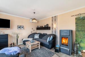 a living room with a couch and a fireplace at Ferienhaus am See mit Boot in Mustin