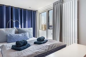 a bedroom with blue curtains and a bed with two towels at Ferienhaus am See mit Boot in Mustin