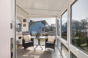 a screened in porch with a table and chairs at Ferienhaus am See mit Boot in Mustin