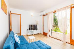 a blue couch in a living room with a large window at Apartamento Felipe 1-4 in Cala d´Or