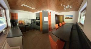 a kitchen with a long table and orange chairs at Ferienhaus Samy - Feldberg in Feldberg