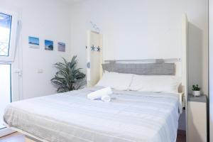 a white bed in a white bedroom with a white at Sibilla house 2 in Olbia