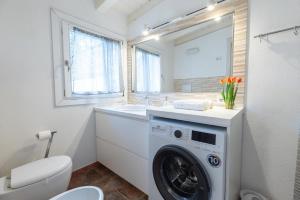 a bathroom with a washing machine and a sink at Sibilla house 2 in Olbia +10 photos